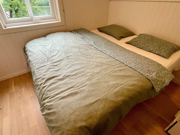 A bedroom with a bed, a window, and a view of greenery outside. - 6 Person Holiday Home in Bjoa (Vindafjord)