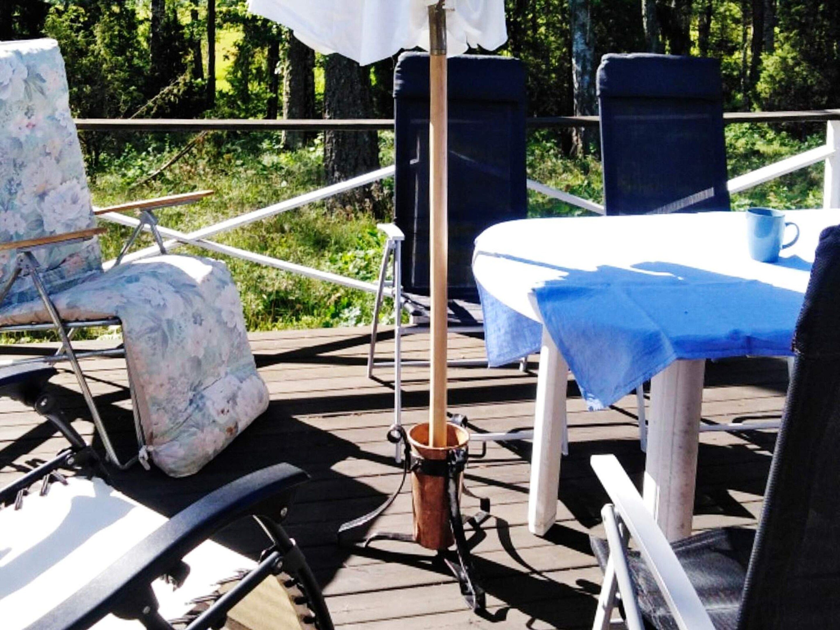 A deck with a table, chairs, and a bucket.