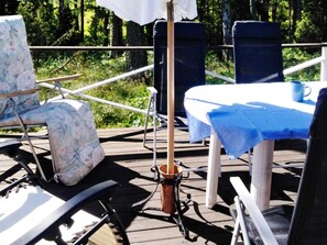 A deck with a table, chairs, and a bucket. - 6 Person Holiday Home in Vingaker (Vingåker)