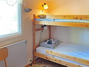 A bunk bed with a desk and a lamp, a window, and a radiator. - 6 Person Holiday Home in Vingaker (Vingåker)