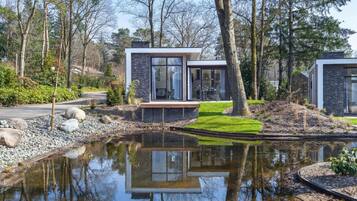 Escape to a serene retreat surrounded by a pond and lush garden.