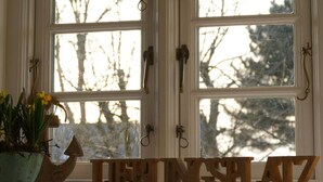 A window with a view of trees and a wooden sign spelling "THE PINGSHAZ." - Favorite Place Modern Retreat (Wrixum)