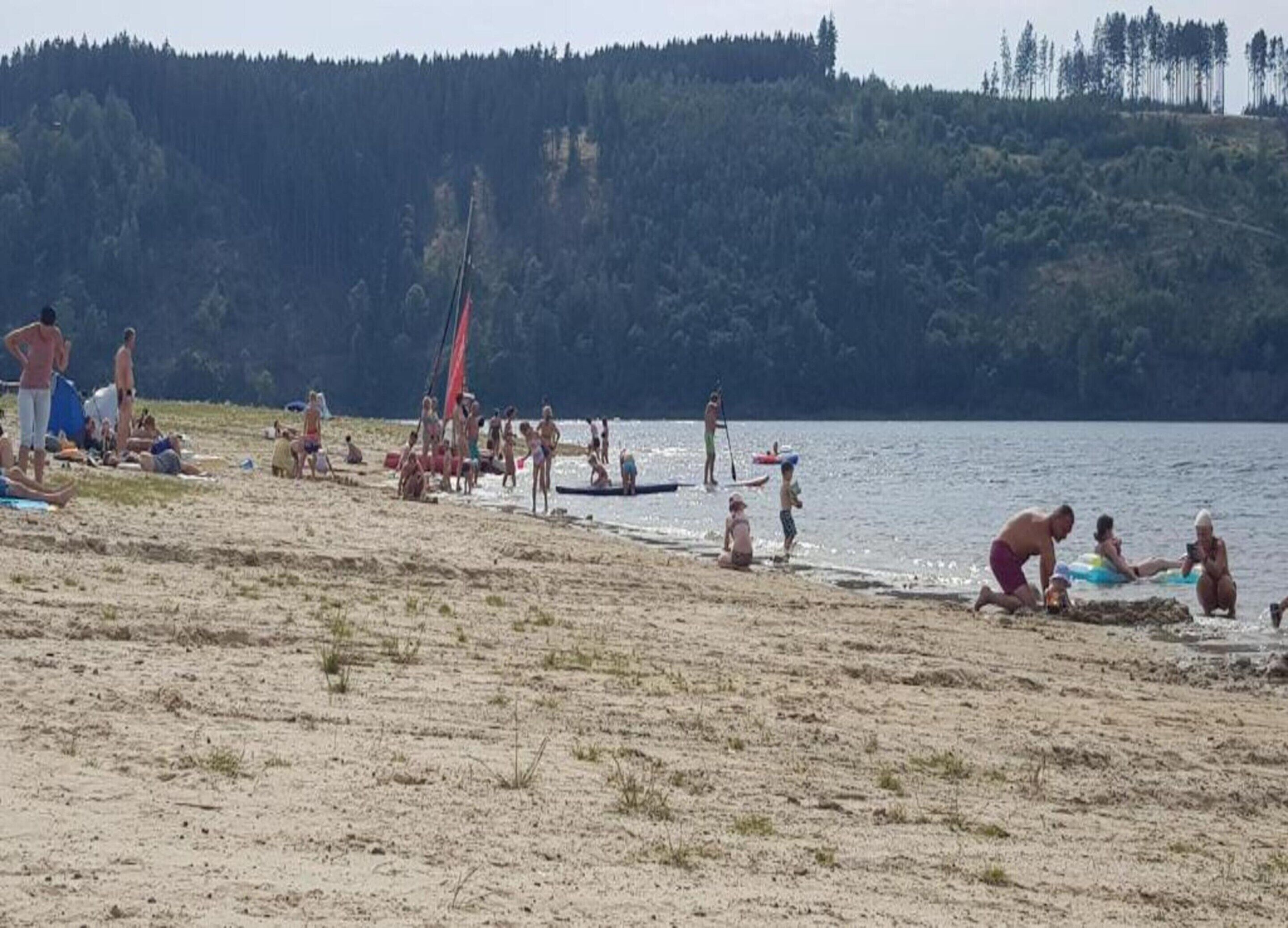 Ein Strand mit Menschen, die sich sonnen und schwimmen.
