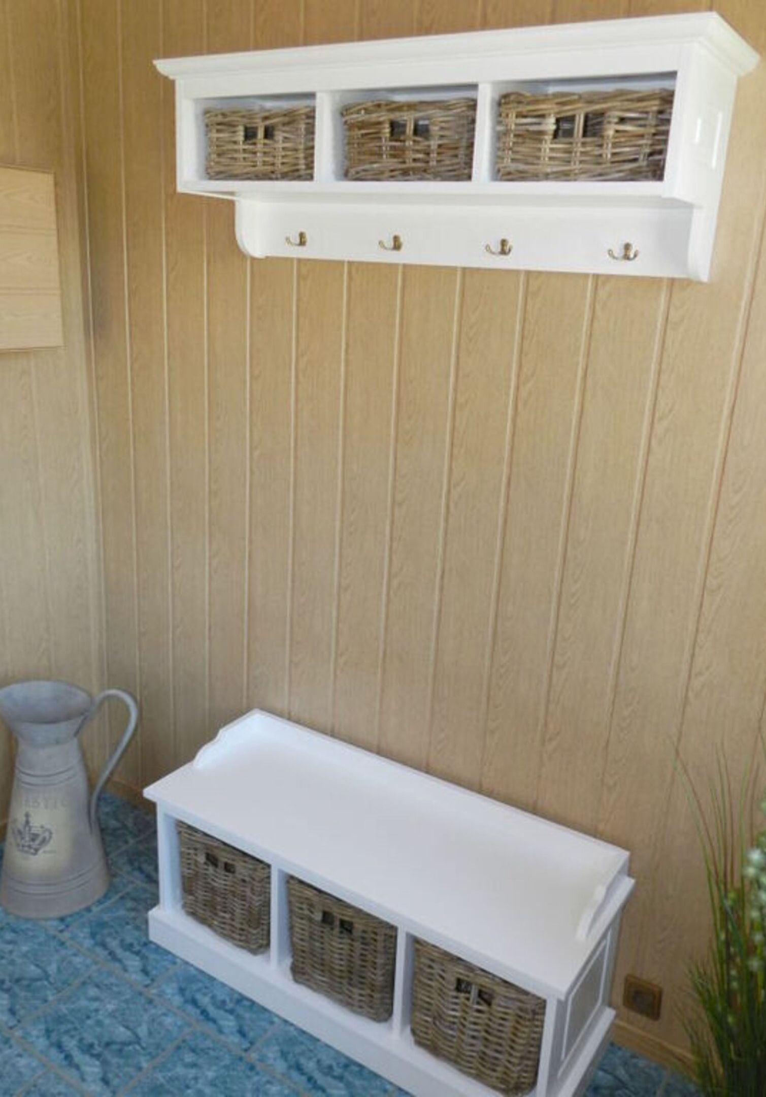 A white storage unit with wicker baskets on a blue tiled floor.