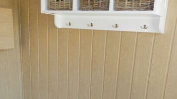 A white storage unit with wicker baskets on a blue tiled floor.