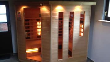 Uma sauna com fachada de madeira, vários painéis de luz e uma porta.
