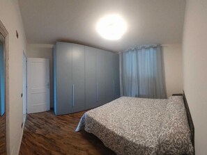 A bedroom with a bed, a wardrobe, and a door.
