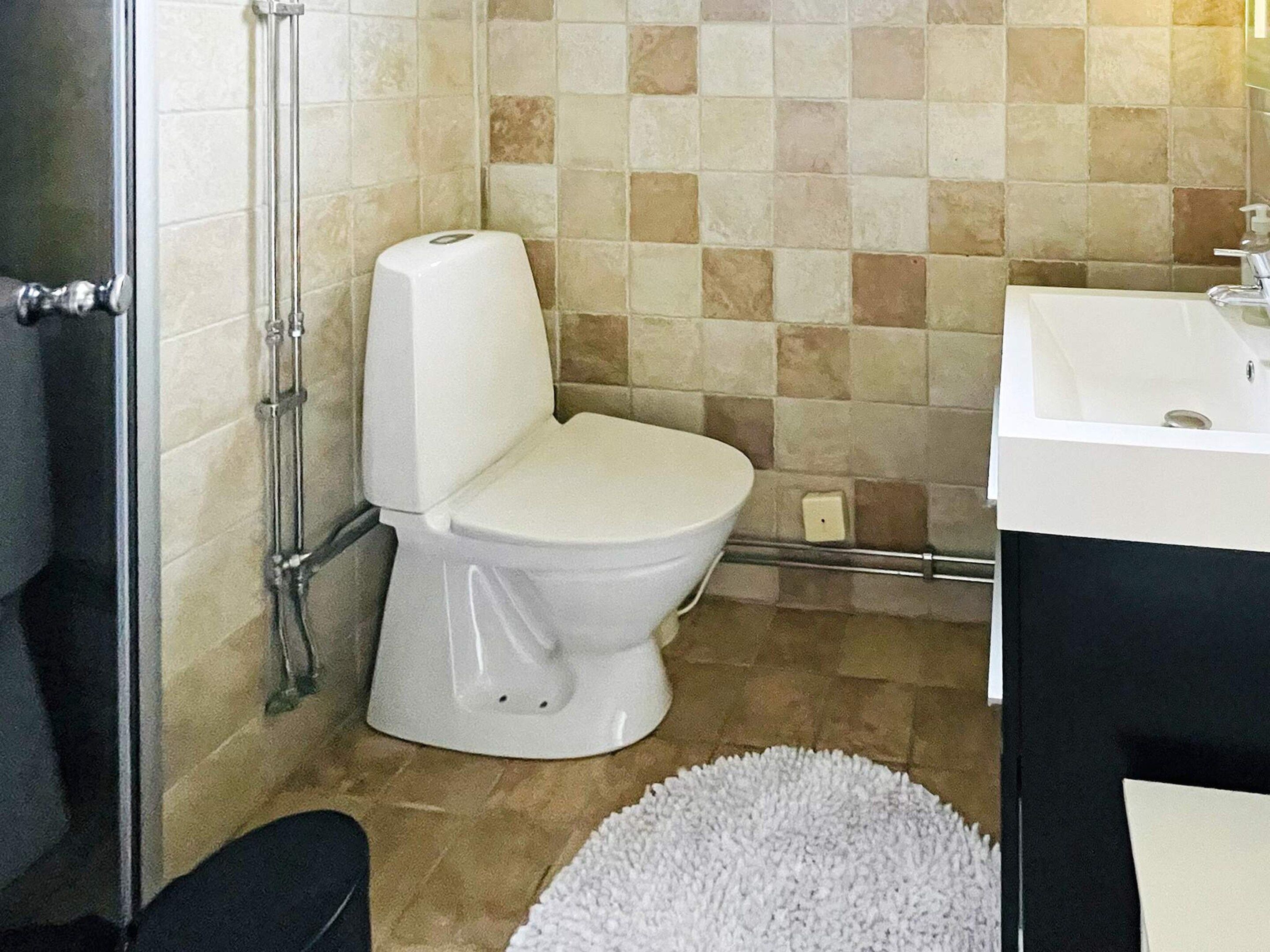 Un baño con inodoro, lavamanos y zona de ducha.