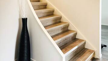 A staircase with wooden steps and a white wall.