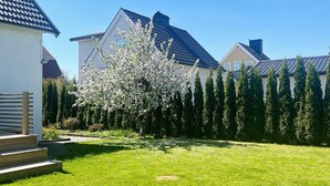 A residential area with a well-maintained lawn, a blooming tree, and houses with distinct architectural styles. - 4 Star Holiday Home in Goteborg (Gothenburg)