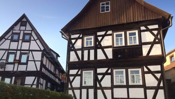 Un bâtiment traditionnel à colombages, doté de nombreuses fenêtres et d’une façade en bois.