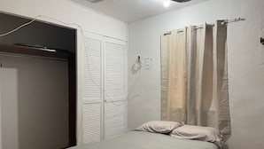 Une chambre à coucher avec un lit, une armoire et un rideau de douche.
