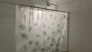 Un rideau de douche orné d’un motif de feuilles.