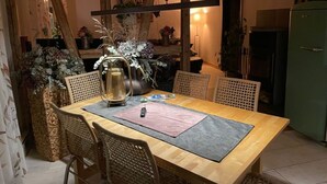 A dining area with a wooden table, wicker chairs, and a pitcher on the table. - Place to Be Modern Retreat (Georgenthal)