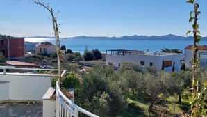 Zona residencial con vista al mar, con casas modernas, un jardín y cielo despejado.