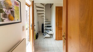 A hallway with a wooden door, a staircase, and a framed picture on the wall. - Charming Holiday Home in Clavier With Garden (Clavier)
