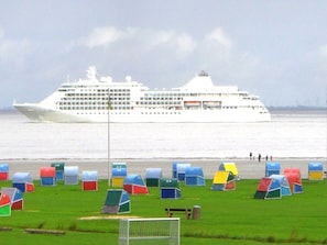 Un navire de croisière était amarré dans un port, avec des tentes aux couleurs vives au premier plan.
