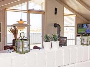 A room with a white brick wall, a hanging lamp, and potted plants. - 4 Star Holiday Home in Hjorring (Hjørring)