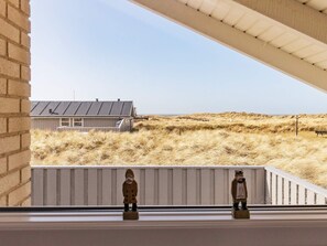 A view from a window overlooking a sandy landscape with a building in the distance. - 4 Star Holiday Home in Hjorring (Hjørring)