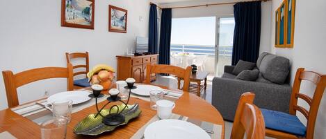 Een zithoek met een tafel voor vier personen, een bank en een balkon met uitzicht.