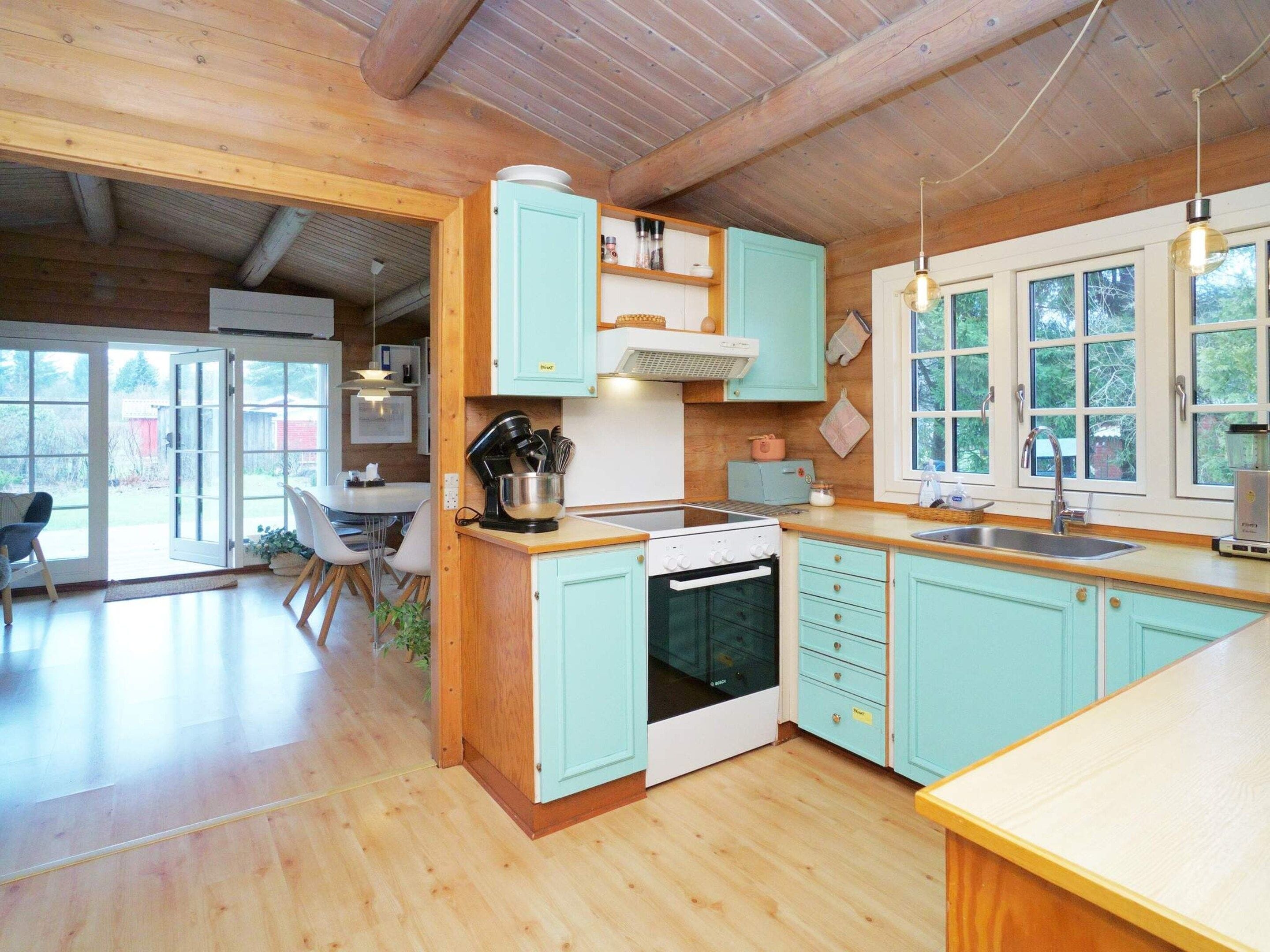 A kitchen with wooden cabinets, a stove, and a sink.