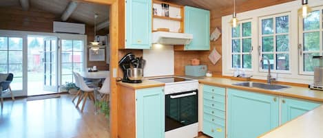 A kitchen with wooden cabinets, a stove, and a sink.