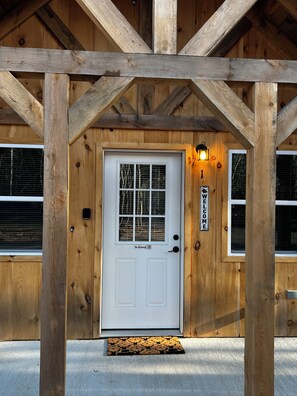A wooden cabin with a white door, a 'No Smoking' sign, and a 'Welcome' sign. - Cabin 1
Recreational Cozy Cabin Rentals (Sangerville)