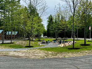 Een camping met picknicktafels, een kleine hut en een grote Amerikaanse vlag.