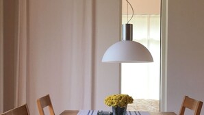 A dining table with a white tablecloth and a vase of yellow flowers. - Holiday Apartment Haus Sundevit (Pruchten)