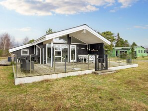 A modern building with a covered outdoor area, large windows, and a deck. - 4 Star Holiday Home in Juelsminde (Juelsminde)