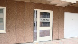 A building facade with a door labeled "westdiep" and a garage door. - Apartment in Nieuwpoort Near the Beach (Nieuwpoort)