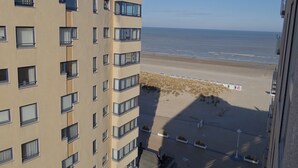 A high-rise building with multiple balconies overlooking a beach. - Apartment in Nieuwpoort Near the Beach (Nieuwpoort)