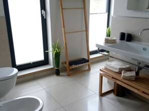 A modern bathroom with a toilet, a sink, a wooden ladder, and a potted plant. - Holiday House House on Muhlfeldsee (Lobnitz)