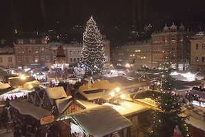 A festive market with a large decorated Christmas tree, traditional market stalls, and historic buildings in the background. - Holiday Home "fuchsbau" (Mildenau)