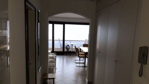 A corridor leading to a balcony with a dining area, a telephone, and a door. - Holiday Apartment Casa Chimp 4 (Gambarogno)