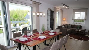 Un coin repas avec une table en bois, dressée pour quatre personnes, entourée de chaises.