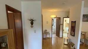 A spacious hallway with wooden flooring, a wooden cabinet, and a deer head decoration on the wall. - Yvonne Comfortable Holiday Residence (Titisee-Neustadt)