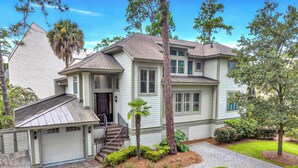 A two-story house with a garage, a covered porch, and a well-maintained lawn. - 2 Genoa Court at The Sea Pines Resort (Hilton Head Island)