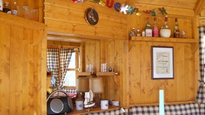 A cozy cabin interior with checkered upholstered seating, a radio, and various bottles on shelves. - "ganseliesel" Comfortable Holiday Residence (Willingen)