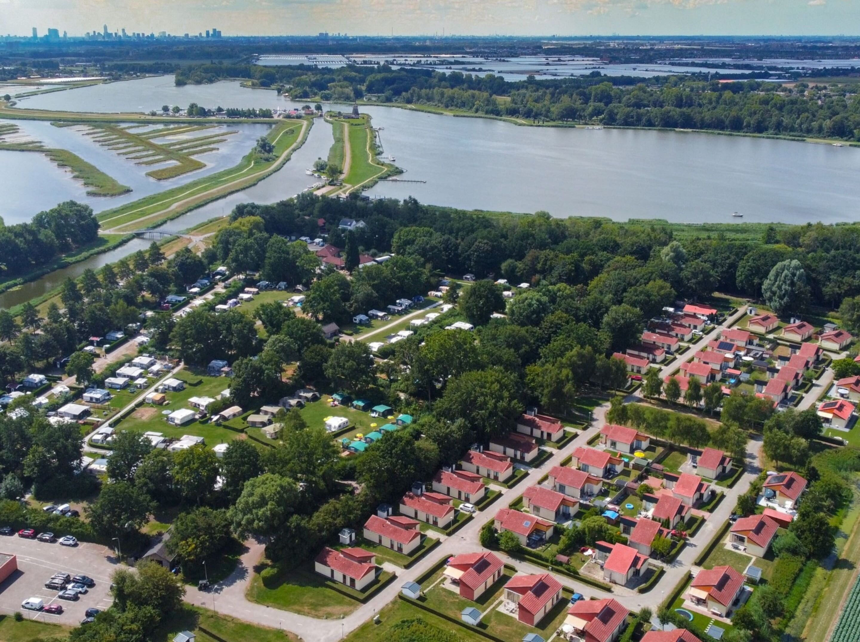 An aerial view of a lakeside residential area with organized housing and a marina.