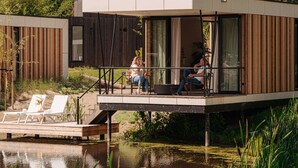 Une péniche moderne dotée d’une terrasse et d’un petit espace jardin.