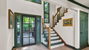 Eine Treppe mit Holzboden und einer grünen Geländer, die zu einer zweiten Etage führt.