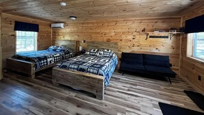 A cabin with two beds, a sofa, a ceiling fan, and a window. - Cabin 2 Recreational Cozy Cabin Rentals (Sangerville)