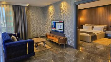 Een moderne hotelkamer met een groot bed, een bank, een televisie en een eethoek.