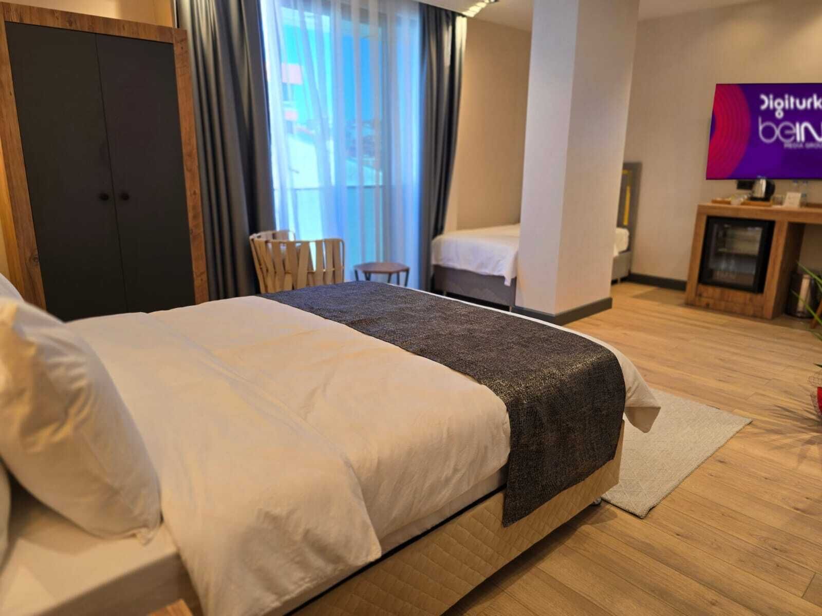 Una habitación de hotel con cama, televisión, escritorio y silla.