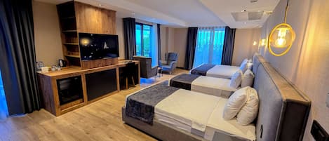 A modern hotel room with two beds, a wooden desk, a television, and a view of the outdoors.