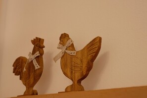 Two wooden chicken sculptures with lace ribbons on a shelf. - Apartment in Mittersill Near ski Lift (Mittersill)