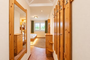 A hallway with wooden doors, a bed, and a mirror. - Apartment in Mittersill Near ski Lift (Mittersill)