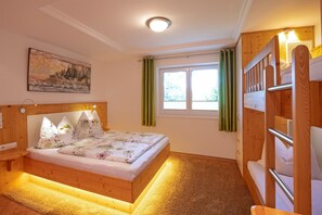A bedroom with a wooden bed, a nightstand, a painting, a window with curtains, and a bunk bed. - Apartment in Mittersill Near ski Lift (Mittersill)