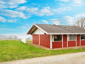 A single-story red building with a tiled roof, a chimney, and a small porch area. - 4 Star Holiday Home in Aabenraa (Aabenraa)